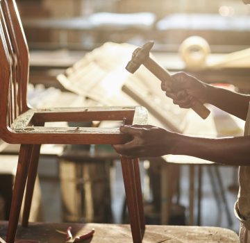 Close up of black artisan fixing on furniture in sunlight Close up of young black artisan fixing on furniture in sunlight, copy space