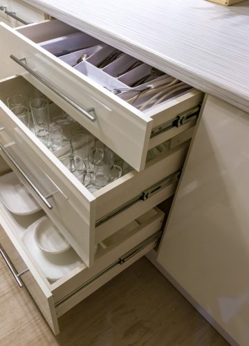 cutlery spoons forks knives and tea spoon on the shelf in the kitchen cupboard